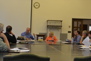 Kyle Swanson holds up the current expenditures for each of UWM’s schools and colleges. Photo by Geoff Marshall.