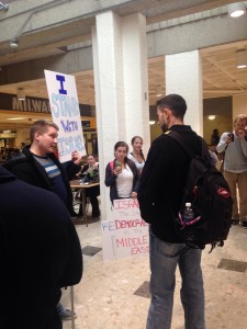 UWM Student-protesters debating during the rally, located in the dining area of the Union.  Supporters of Israel holding signs that read, “I Stand with Israel”, “Israel: the Last Democracy in the Middle East” and “All Israel wants to do is Exist.”  Photo by Melissa Leverenz.