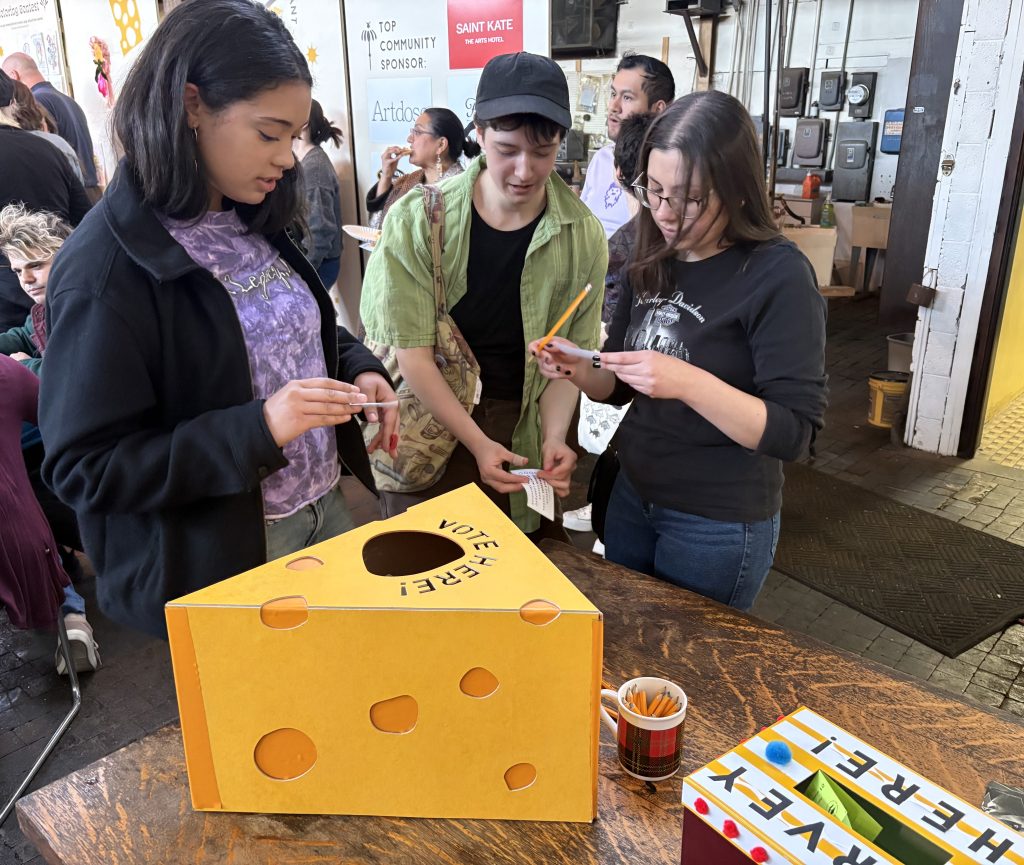 Attendees casting their vote in a giant cardboard block of cheese. 