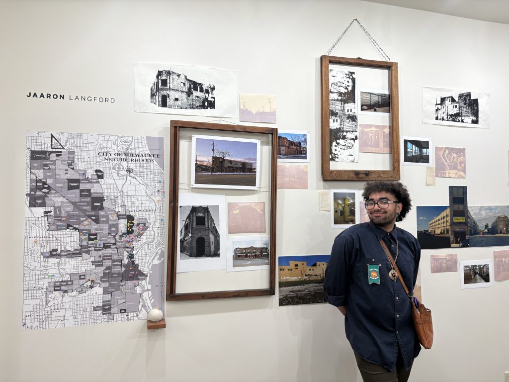 Laangford poses in front of his photo display. 