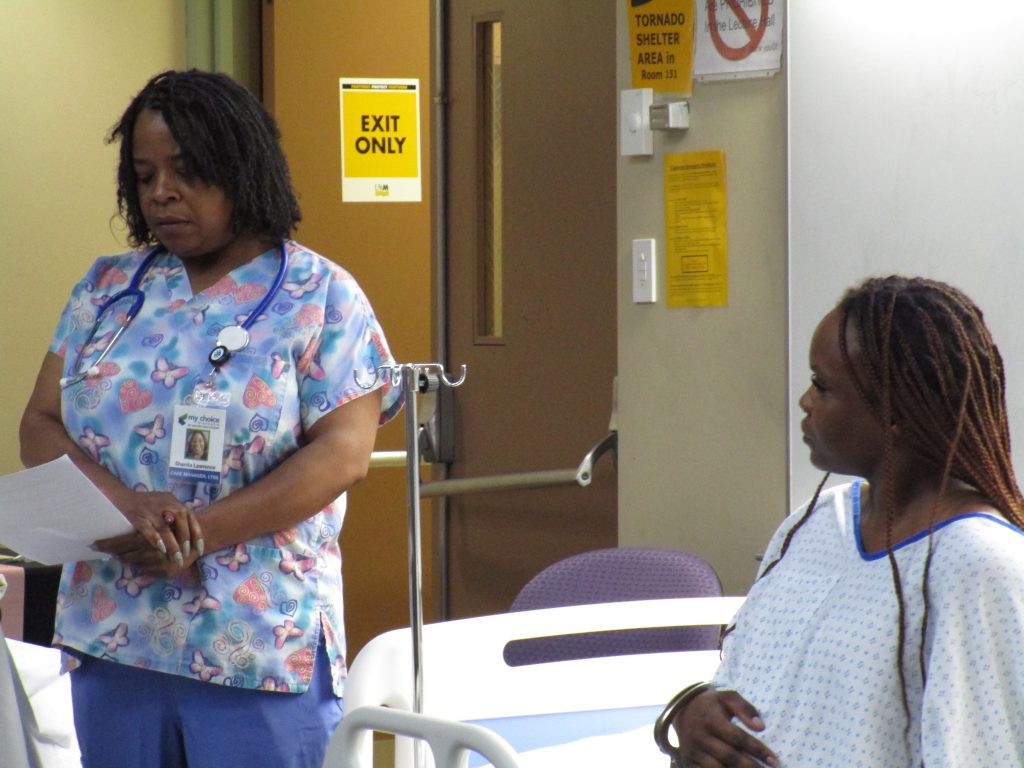 Doula Shanita Lawrence and Markesha Hollins stand beside each other during the prison birth recreation.
