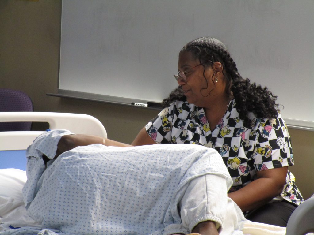 Doula Tracey Russell sits beside actress Markesha Hollins during the prison birth recreation.