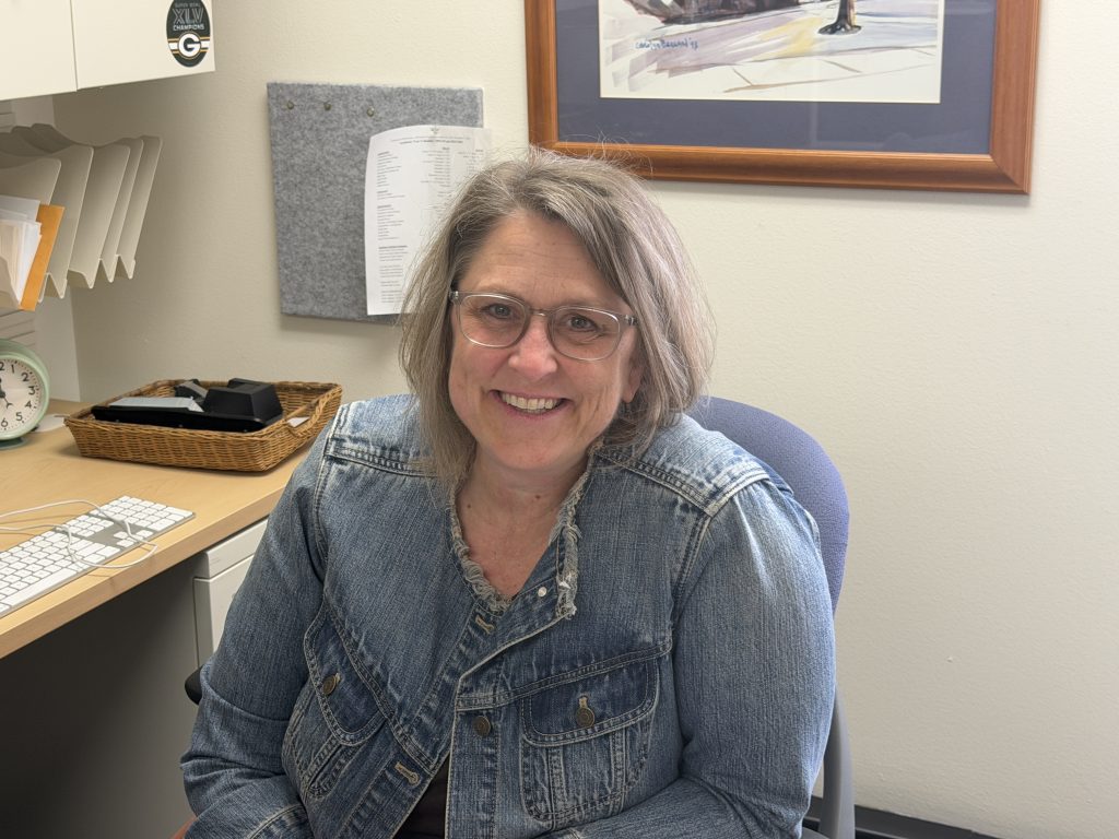 Sara Benesh, professor of political science and director of curriculum and governance at UWM, sitting at her desk